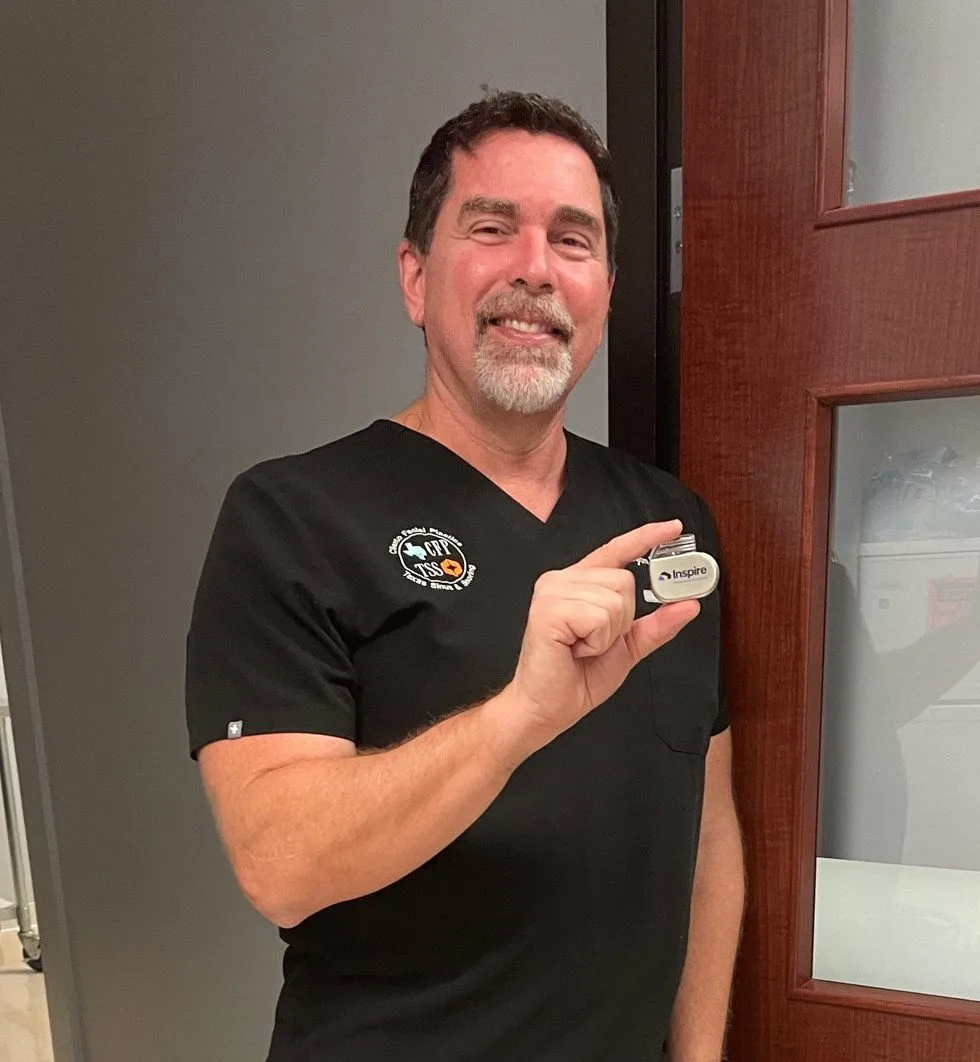 Dr. Ben Cilento holding a sleep apnea oral appliance device in the practice hallway